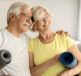 An older man and woman hugging and touching heads together, carrying rolled up yoga mats and smiling. Glad for a better outcome for leg cramp prevention.