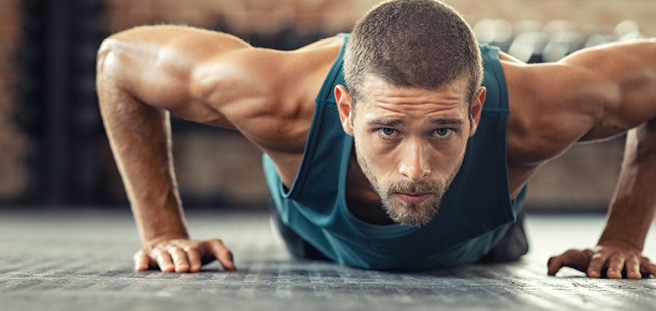 A man with big arm muscles, doing a push up. Preventing Leg Cramps During Exercise: Tips for Active Individuals